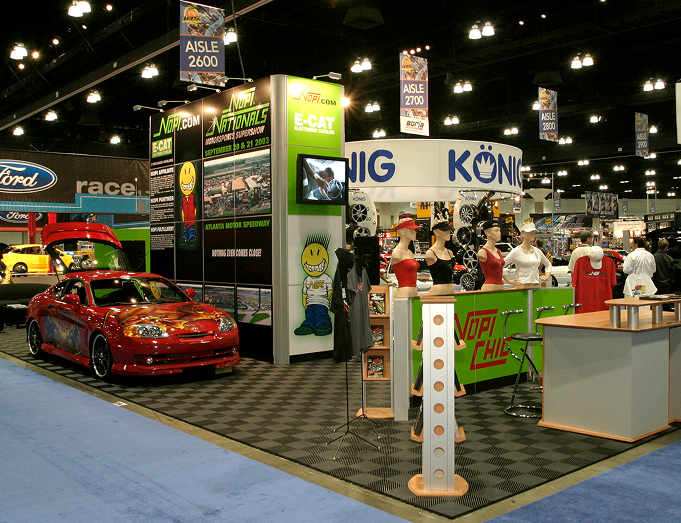 Automotive trade show booth with custom performance cars and displays.