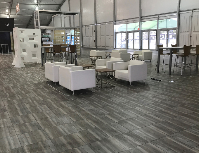 Modern office space with white chairs, tables, and large windows.
