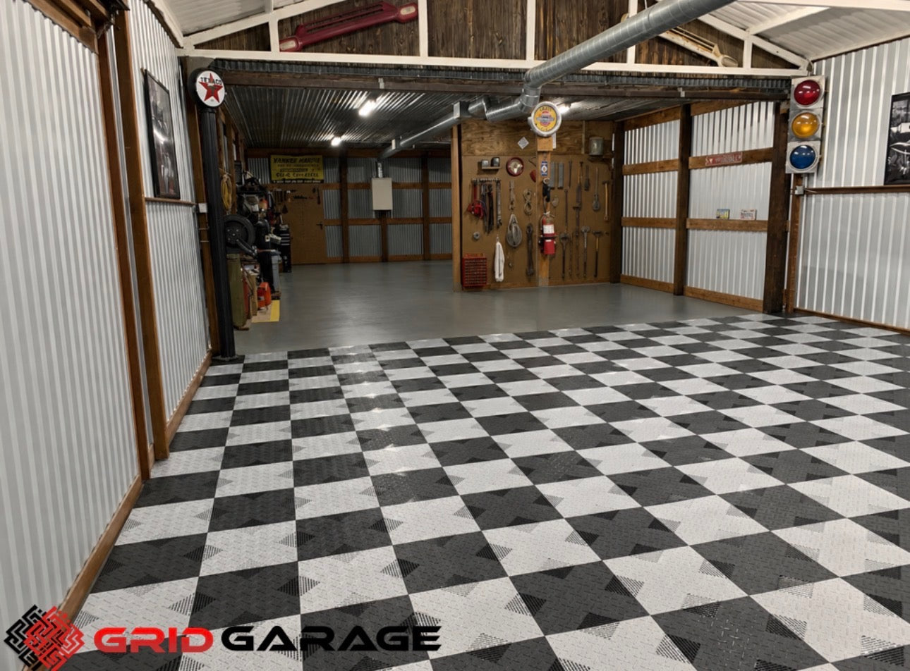 Garage interior with checkered floor and various tools on the walls, featuring the Grid Garage logo.