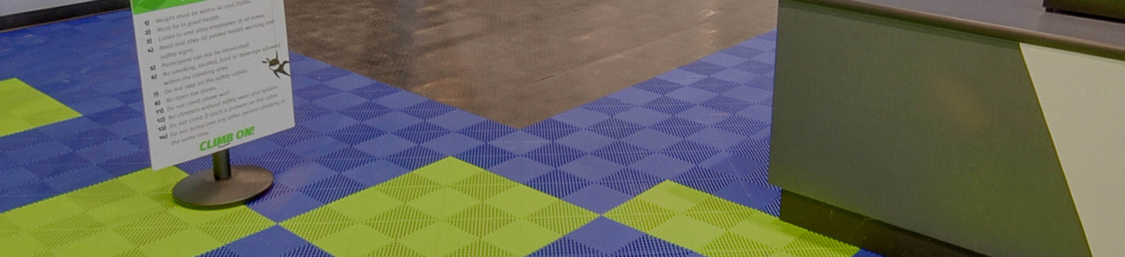Green and blue checkered floor with a sign on a stand.
